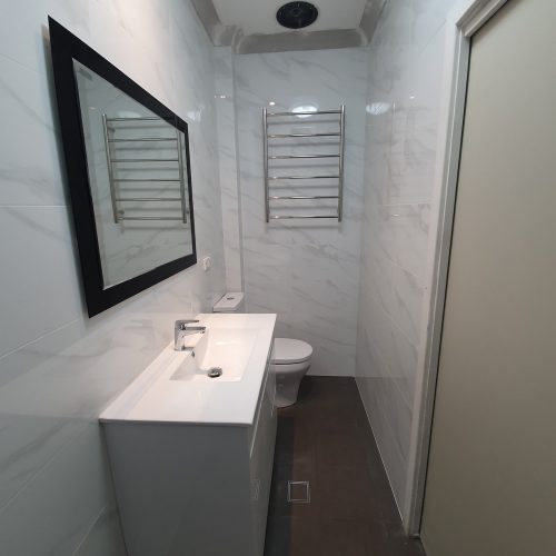 Completed modern bathroom with vanity, toilet and floor waste
