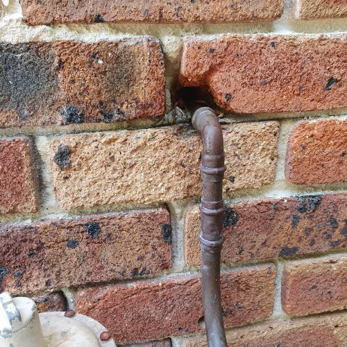 New copper gas pipe connection through a double-brick wall