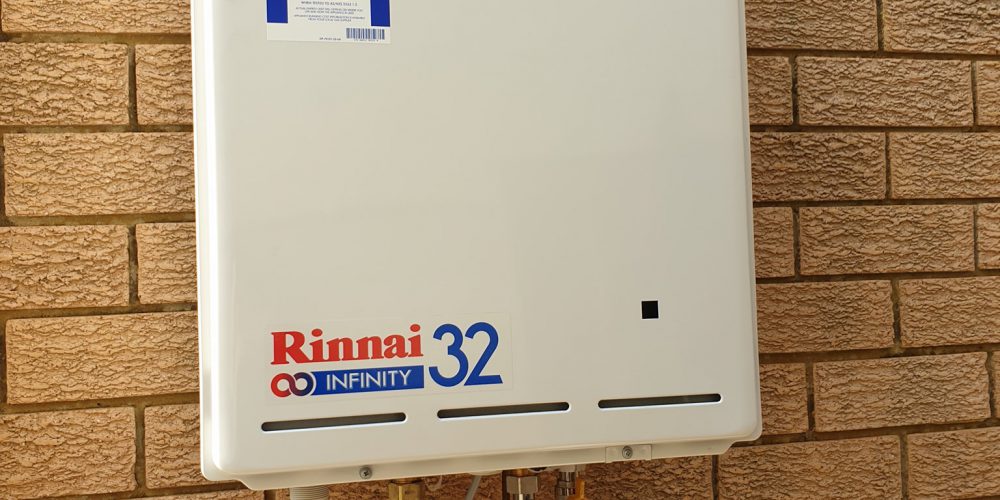 Rinnai Infinity 32 instantaneous hot-water unit installed on a brick wall