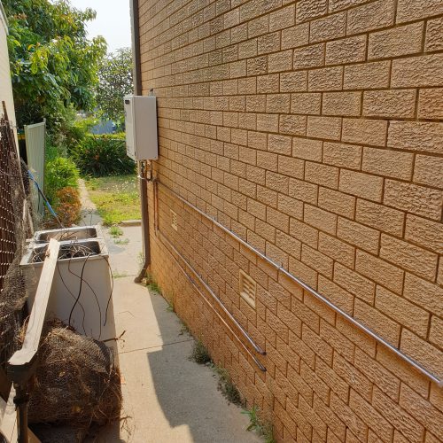 External hot-water installation with copper lines along a side passage