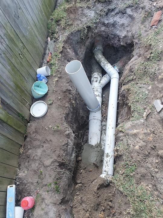 Drain repair with newly installed PVC drainage pipework before backfilling