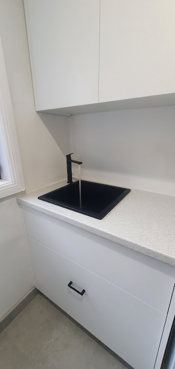 Completed black laundry sink and tap installation